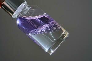 violett tvåfaktor serum med dropper och flaskor. foto