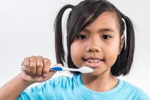 liten flicka borstar tänderna i studio skott. foto