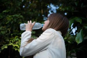 vacker affärskvinna som dricker vatten efter hårt arbete foto