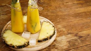 färsk ananasjuice med is i en liten glasflaska foto