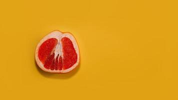 skivad röd grapefrukt med kopia utrymme på ljusgult foto