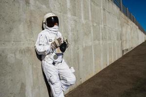 kvinna astronaut utan hjälm på bakgrunden av en grå vägg foto