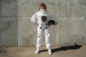 kvinna astronaut utan hjälm på bakgrunden av en grå vägg foto