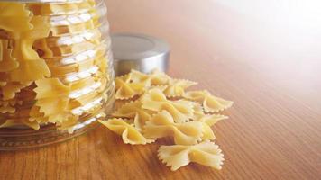 pasta i form av rosetter utspridda från glasburk foto