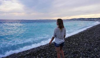 trevligt, frankrike. ung kvinna som njuter av den azurblå kusten foto