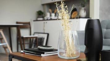 en vas med torra blommor på ett bord. skandinavisk foto