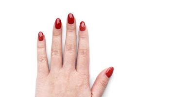vacker kvinnlig hand med röd manikyr och nagel isolerad på vitt foto