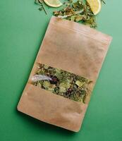 blad te spillts ut av en papper paket med orange skivor på grön bakgrund foto