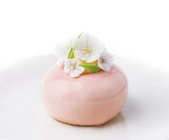 rosa mousse kaka dekorerad med vit blommor foto