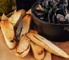 traditionell utegrill italiensk blå mussla i vin sås med baguette bröd foto