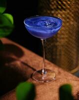cocktail baserad på kolsyrad dryck i en skön glas på en tunn lång ben foto