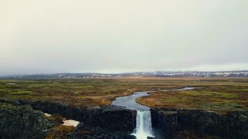 majestätisk oxarafoss kaskad panorama, antenn se av isländsk vattenfall löpning ner av berg. massiv flod ström strömmande och faller av stor klippig klippor i island. långsam rörelse. foto