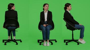 caucasian affärskvinna bär kostym och Sammanträde på stol, väntar i förberedelse över full kropp grön skärm bakgrund. ung vuxen arbetssätt som företags- anställd varelse positiv i studio. foto