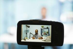 bloggare strömning medan skapande digital innehåll och inspelning video med professionell kamera närbild. afrikansk amerikan vlogger inspelning video och sändningar leva för podcast foto