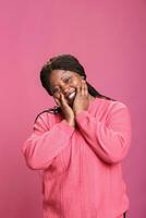 afrikansk amerikan kvinna Framställ med lycklig Lycklig ansiktsbehandling uttryck på kamera, känsla avslappnad och tillfällig i studio. kvinna person med förtroende lurar runt om och verkande rolig, varelse upphetsad. foto