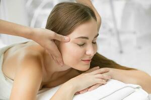 hälsa vård skönhet kvinnor huvud massage i spa smärta lättnad koppla av för friska livsstil. skön lady kropp vård behandling närbild ansiktsbehandling. foto