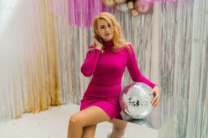 studio Foto av skinande blond kvinna i sexig rosa klänning. perfekt vågig hårstrån. ny år fest.