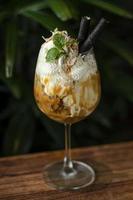 gourmet ekologisk kokos och karamell med glass sundae dessert i vinglas foto