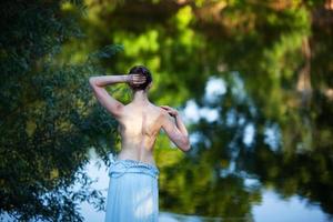 smal ung kvinna klär av sig innan hon simmar foto