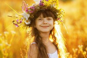 glad söt tjej som bär en krans av blommor