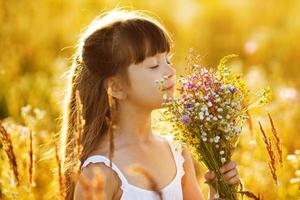 glad tjej med en bukett med vilda blommor foto
