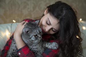 ung kvinna med en stor grå katt foto