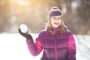 glad ung kvinna med snöboll foto