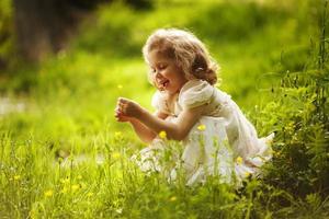 rolig glad liten flicka med en blomma