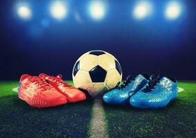 två par av fotboll skor och en boll på de jord som en tecken av utmaning foto