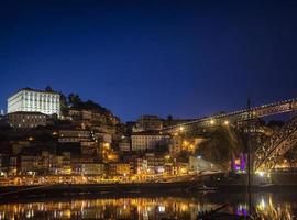 porto ribeira vid flodens gamla stad och landmärke över bron i Portugal på natten foto