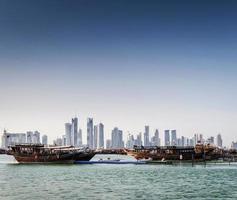 Doha stads skyskrapor urbana silhuettvy och dhow -båt i Qatar foto