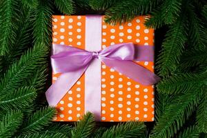 topp se av festlig gåva låda dekorerad med grön gran träd grenar. jul tid med kopia Plats foto