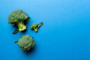 topp se färsk grön broccoli vegetabiliska på färgad bakgrund. broccoli kål huvud friska eller vegetarian mat begrepp. platt lägga. kopia Plats foto