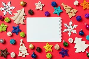 topp se av anteckningsbok på röd bakgrund tillverkad av Semester dekorationer och leksaker. jul prydnad begrepp foto