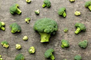 grön färsk broccoli bakgrund stänga upp på färgad tabell. grönsaker för diet och friska äter. organisk mat foto