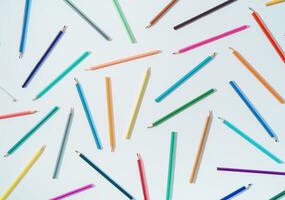 kreativ färgrik mönster tillverkad av färgad pennor på vit bakgrund. minimal tillbaka till skola begrepp. trendig färgad pennor mönster aning. platt lägga bakgrund. foto