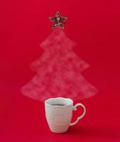 jul träd tillverkad av ångande kaffe eller te med rutig stjärna på de topp mot röd bakgrund. vinter- Semester begrepp. minimal ny år bakgrund. trendig jul aning. kopia Plats. foto