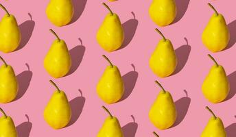 trendig frukt mönster tillverkad av gul päron på ljus pastell rosa bakgrund. minimal layout. natur sommar begrepp. foto