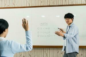 asiatisk manlig lärare som undervisar elever i klassrummet foto