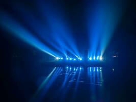 skön laser lampor, blå laser i de rök är reflekterad från mörk sjö, ett abstrakt spela av ljus med reflexion. foto