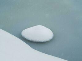 selektiv fokus. vår is, små snöig runda ö på smältande is. abstrakt naturlig bakgrund. foto