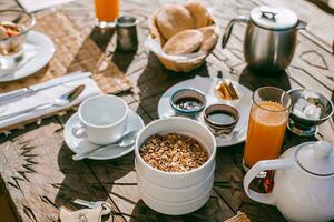 frukost med kaffe, orange juice och granola på trä- tabell foto