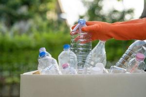 asiatisk kvinna volontär bära vatten plastflaskor i soporna foto