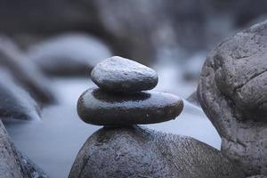 en närbild av stenar på en suddig flodbakgrund foto