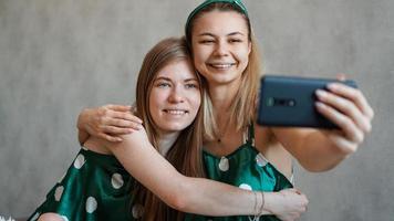 vackra glada flickvänner som tar selfie med smartphone