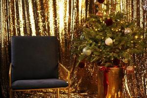 nyår interiör. julgran med gulddekorationer. foto