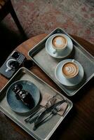 cappuccino med choklad kaka och kamera på de trä- tabell foto