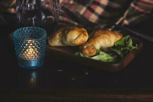 två empanadas och en glas av vin i en chic reträtt. foto