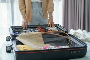 kvinna förpackning resväska på säng för en ny resa förpackning lista för resa planera framställning semester bok nu reser transport foto