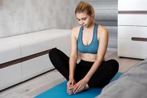 glad fitness kvinna yoga slappna av meditation i fjäril poserar hemma. foto